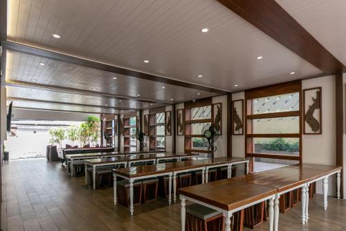 a restaurant with wooden tables and windows at A Sleep Bangkok Sathorn in Bangkok