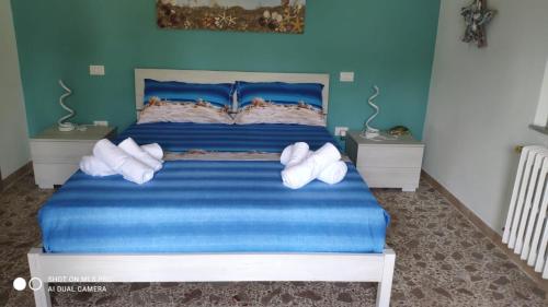 Un dormitorio con una cama azul con zapatos blancos. en Tra cielo e mare en Francavilla al Mare