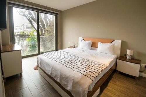 um quarto com uma cama grande e uma janela grande em Accra Pearl in City em Acra