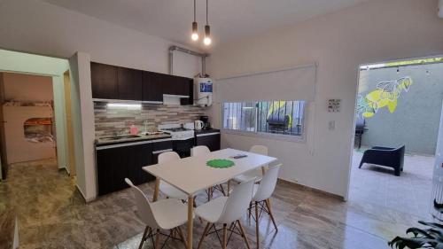 cocina y comedor con mesa y sillas en BELLA VISTA Hostel, Aparts & Complejo de Cabañas en Santa Rosa de Calamuchita