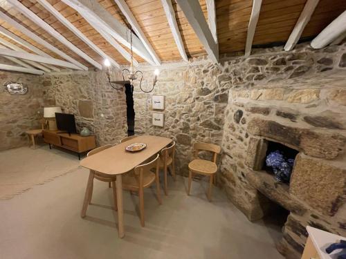 a room with a table and a stone fireplace at SantiagoFamilyHouse - Casa Velha - Cottage in Sever do Vouga