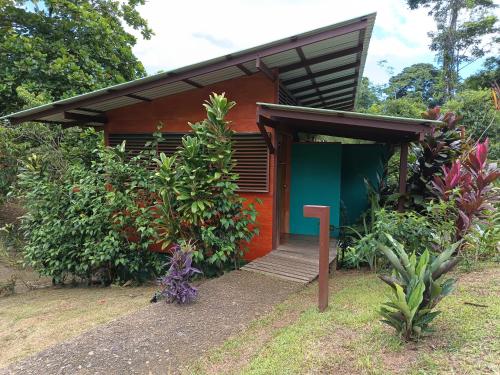 a small house with a green and red exterior at Hotel Finca Maresia in Drake