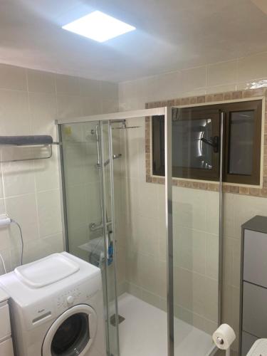 een badkamer met een wasmachine en een douche bij Apartamento Tobias Agaete Parque Playa del Ingles in San Bartolomé