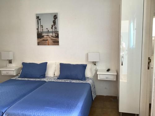 sypialnia z niebieskim łóżkiem i niebieskimi poduszkami w obiekcie Apartamentos Playamar II w mieście Valle Gran Rey