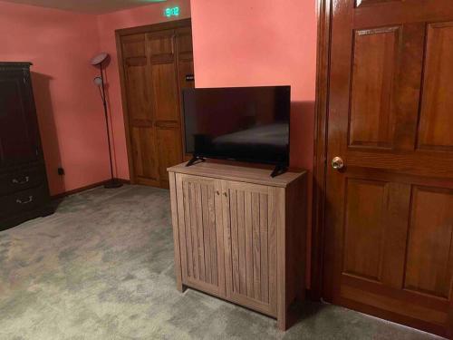 uma televisão em cima de um suporte de madeira numa sala em Full House/Heart of Worcester em Worcester