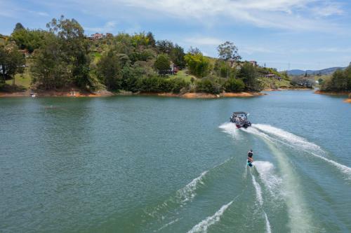 a person riding a boat in the water at Glamping Montecarlo Lodge Cubo de Madera-Guatapé in Guatapé