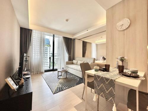 a living room with a couch and a table at Sukhumvit 11#Luxury#Pool#Gym#BTS Nana&MRT Sukhumvit#1BR#Max4ppl in Bangkok