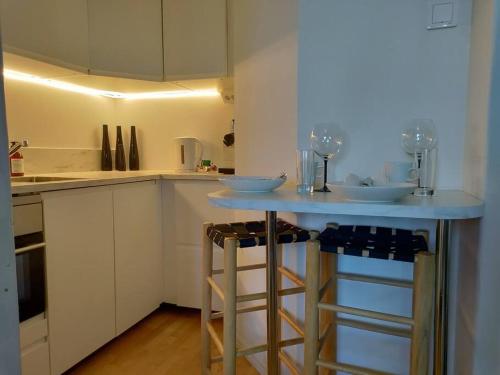 a kitchen with a blue counter with two stools at Top-floor studio, near park & sea, great transit in Helsinki