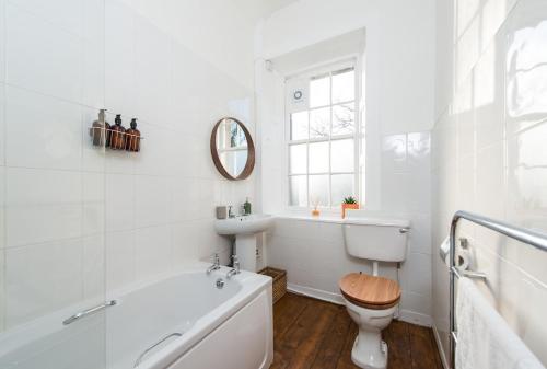 a bathroom with a tub and a toilet and a sink at Stunning Stables Cottage in East Lothian Country Estate in North Berwick
