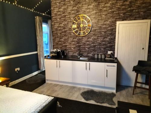 a kitchen with a sink and a clock on the wall at THE NEW INN Newton Derbyshire in Tibshelf