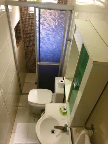 a small bathroom with a toilet and a shower at Pousada Maraka in Florianópolis