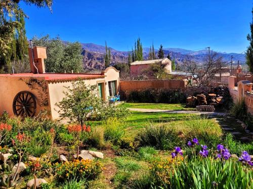 a garden in front of a house with flowers at Los Arcabuceros Posada Boutique in Tilcara