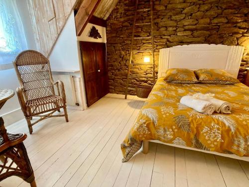 a bedroom with a bed and a stone wall at Penty LEGONA, authentique et chaleureux, 2-6 pers in Moëlan-sur-Mer