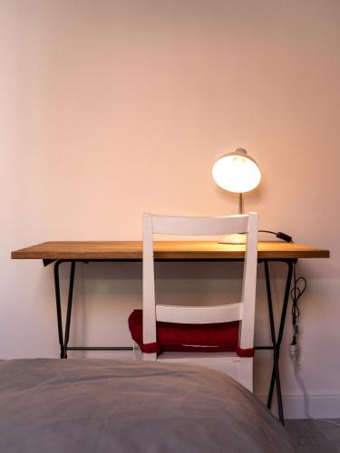 un bureau avec une chaise et une lampe. dans l'établissement Logement Le Serein, à Toulon