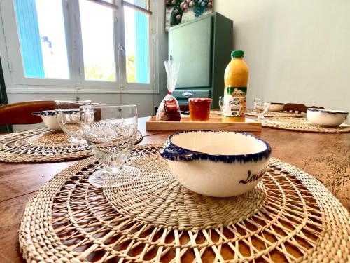 a wooden table with a bowl and glasses on it at Penty LEGONA, authentique et chaleureux, 2-6 pers in Moëlan-sur-Mer