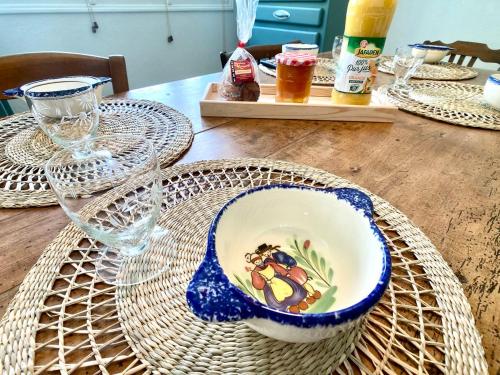 a wooden table with plates and glasses on it at Penty LEGONA, authentique et chaleureux, 2-6 pers in Moëlan-sur-Mer