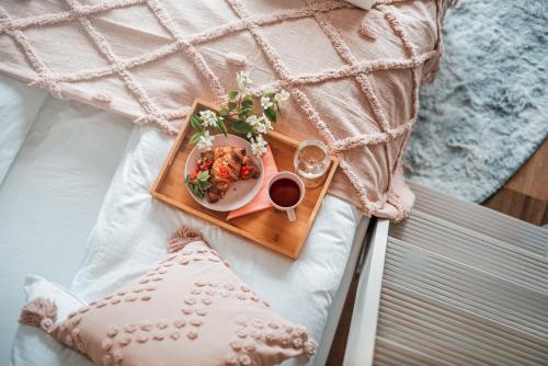 a plate of food and a cup of coffee on a bed at Glamping Bobrowniczki w Kotlinie Kłodzkiej in Szczytna