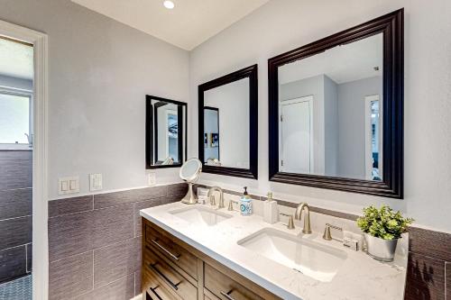 a bathroom with two sinks and two mirrors at Port of Call in Port Charlotte