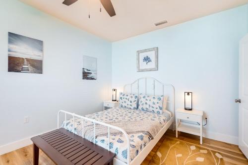 a white bedroom with a bed and a table at The Blue Heron Cottage in St. Augustine