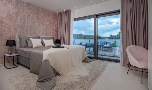 Schlafzimmer mit einem Bett und Blick auf einen Balkon in der Unterkunft Luxury villa Indigo with swimming pool, sauna and jacuzzi in Kanica - Rogoznica in Sevid