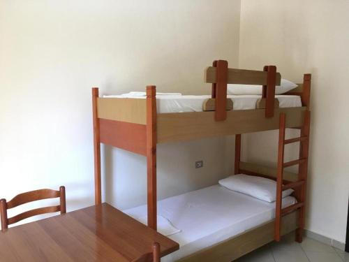 two bunk beds in a room with a table at Zak's Apartments in Ksamil