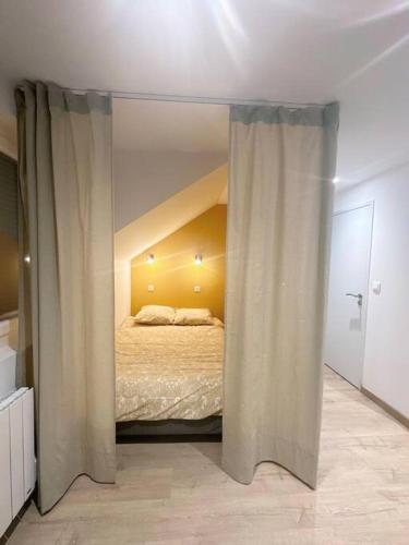 - une chambre avec un lit et des rideaux dans l'établissement / /Sacré studio/ /wifi/ /parking privé, à Rodez