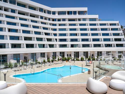 um grande edifício de apartamentos com uma grande piscina em Nathan's Suites On The Beach em Eilat