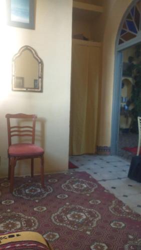 a room with a red chair and a red rug at La Maison Haute Larache Morocco in Larache