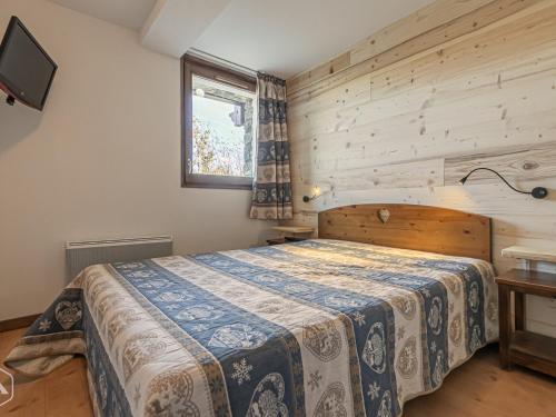 Appartement Aussois, 3 pièces, 6 personnes - FR-1-508-5 في أوسوا: غرفة نوم بسرير وجدار خشبي