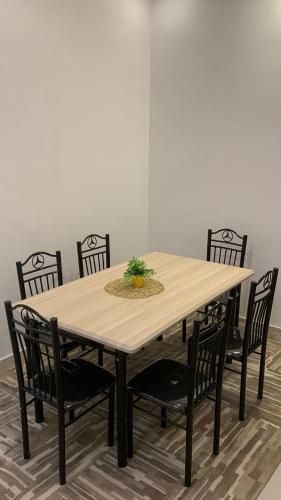 a wooden table with four chairs around it at شقق بيوتات الريف للشقق المخدومة in Najran