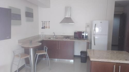 uma cozinha com um frigorífico, uma mesa e um balcão em Suite Lof 206 em Monterrey