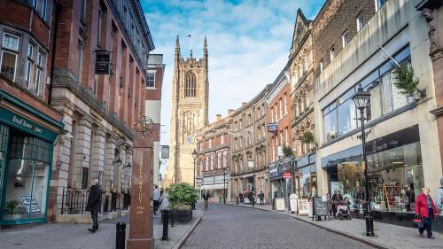 una calle de la ciudad con una torre de reloj en la distancia en Deluxe Studio Apartments en Derby