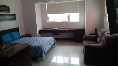 um quarto com uma cama, um sofá e uma secretária em Suite Lof 206 em Monterrey