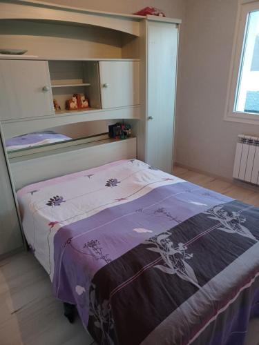 1 dormitorio con 1 cama con manta morada en Chez phiphi, en Ernée