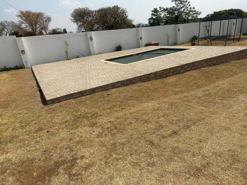 a swimming pool in a yard next to a fence at Mphagahle B&B in Mthenti