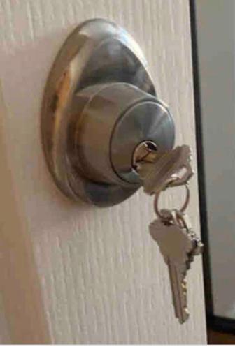 a metal door knob on a door with a key at Clover House in Peterborough