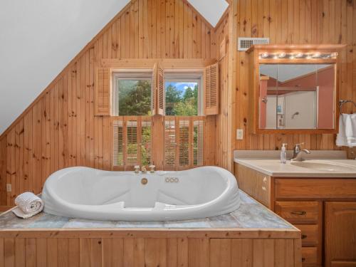 une salle de bain avec une grande baignoire et un lavabo dans l'établissement Luxury Cabin 45 Min to Asheville Hot Tub & Fire pit, à Marion