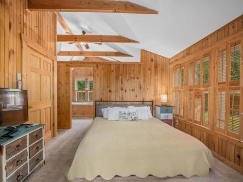 een slaapkamer met een bed en een tv. bij Luxury Cabin 45 Min to Asheville Hot Tub & Fire pit in Marion
