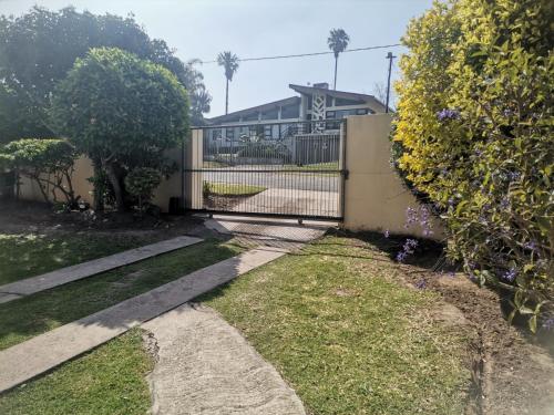 a fence in front of a house with a yard at Izibusiso Guest room in East London