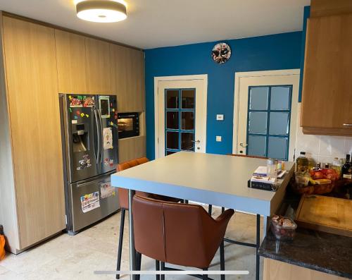 a kitchen with a table and a refrigerator at Relax in Kasterlee