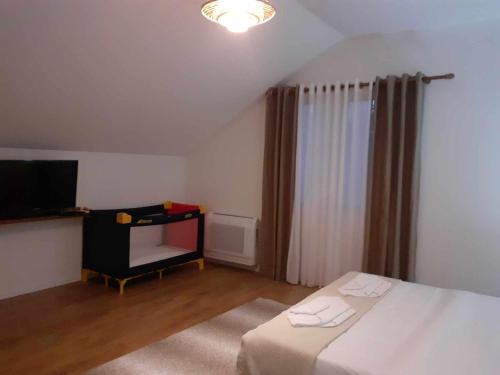 a bedroom with a bed and a tv and a table at Bujtina Bezhani Gjinar in Elbasan