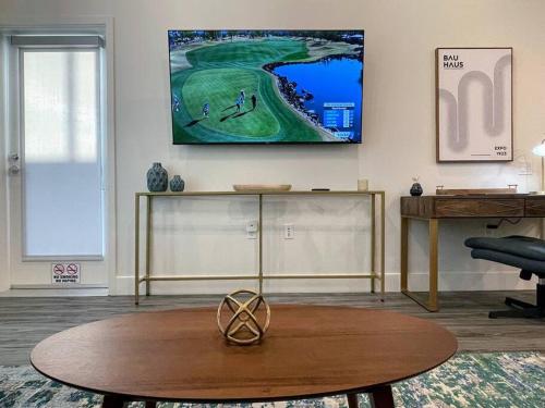 a living room with a table and a tv on the wall at Bright Top Floor-Elevator-Walk Downtown-Laundry in Walnut Creek