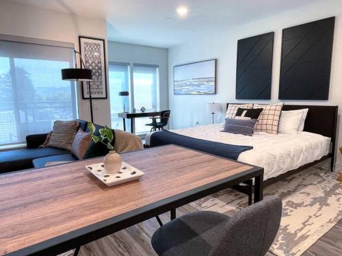 uma sala de estar com uma cama e uma mesa de madeira em Elevator-Downtown View-Garage-King Bed-Laundry em Walnut Creek