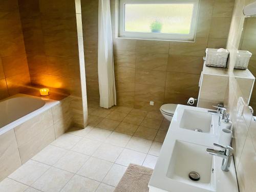 a bathroom with a sink and a tub and a toilet at Rodinný dům Zelená 