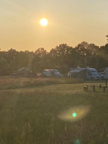 un champ avec le coucher du soleil en arrière-plan dans l'établissement Blockhütte 2, à Dötlingen