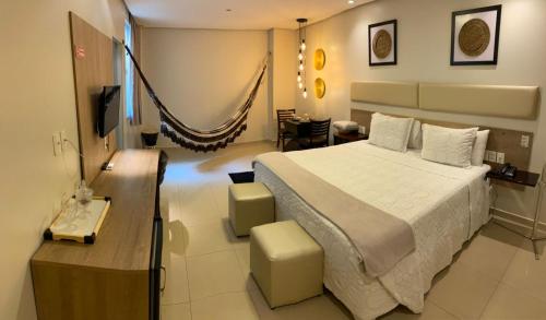 a bedroom with a large bed and a dining room at Hotel Palace Santarém Brasil in Santarém