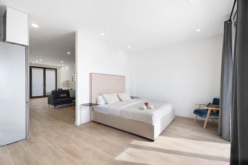 ein weißes Schlafzimmer mit einem Bett und ein Wohnzimmer in der Unterkunft Apartment punta Hidalgo in Punta del Hidalgo