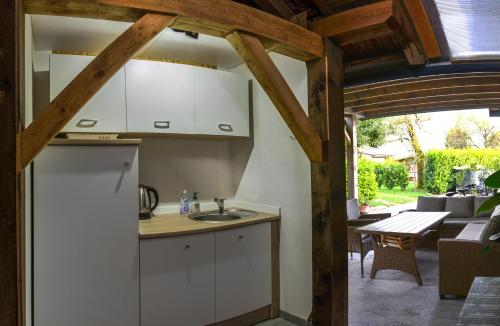 una cucina con armadi bianchi, un tavolo e un patio di Glamping with a view a Smlednik