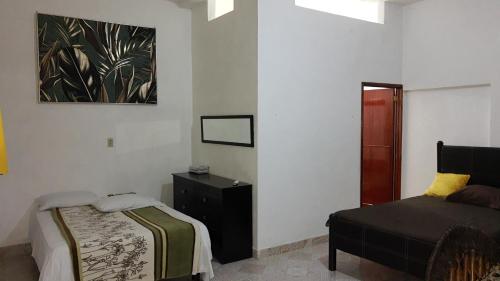 um quarto com uma cama e uma cómoda em Departamento en la 43 em Oxkutzcab
