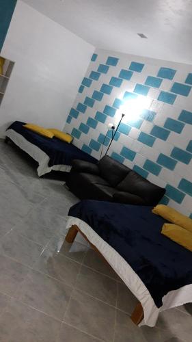 um quarto com duas camas e uma luz na parede em Departamento en la 43 em Oxkutzcab